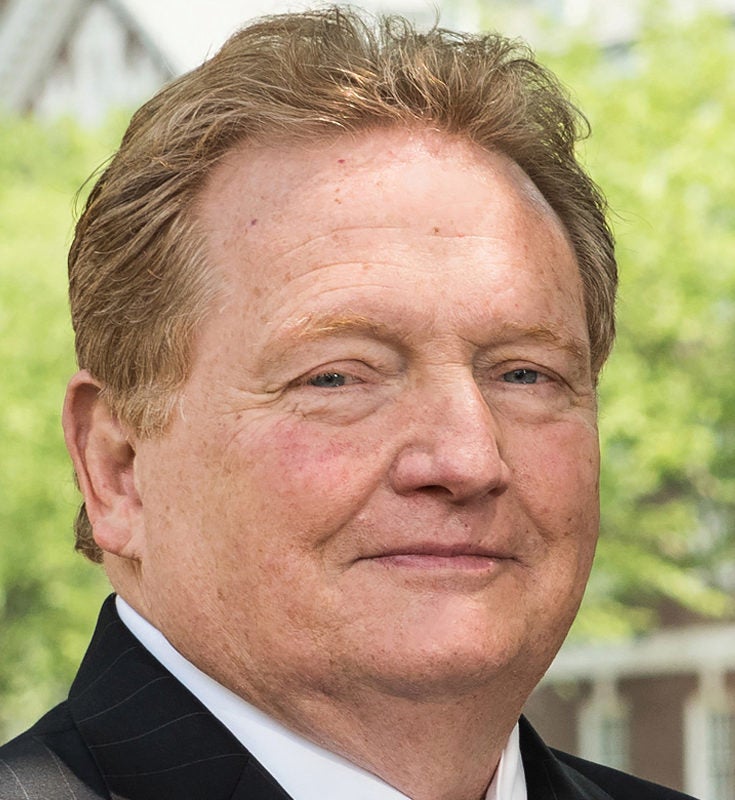 Scott Douglass, outdoors in a pinstriped suit.