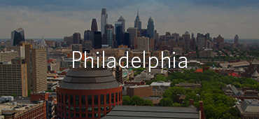 Aerial view of Philadelphia''s skyline with tall buildings and greenery, overlaid with the word "Philadelphia".